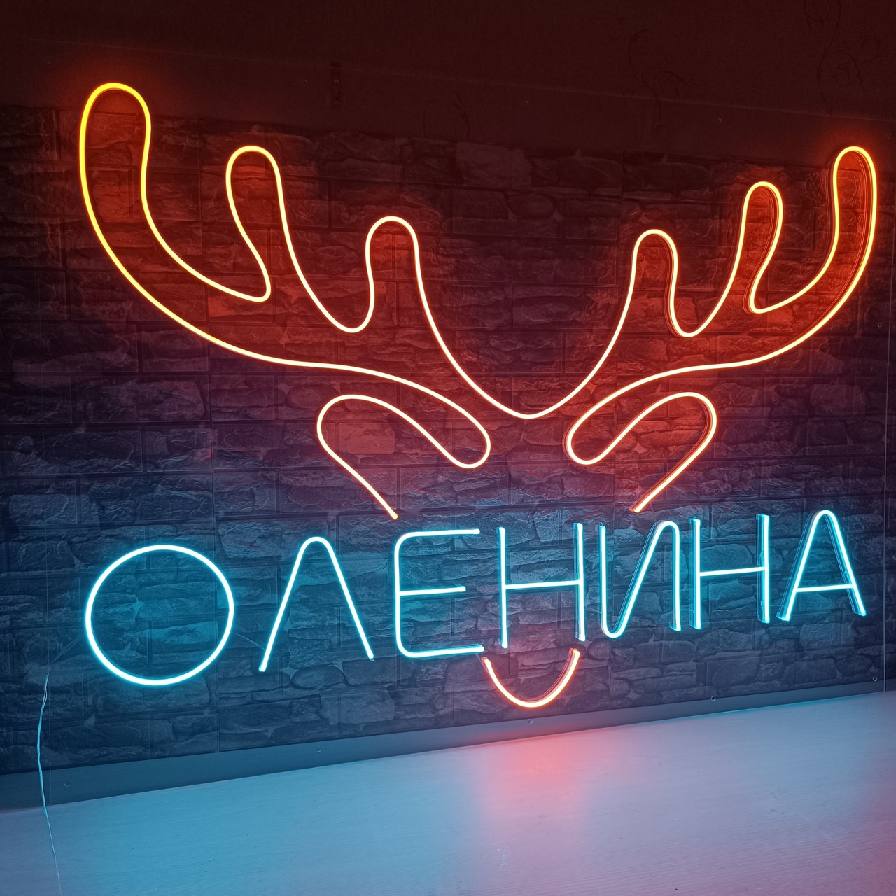 Неоновая вывеска с рогами оленя и текстом ОЛЕНИНА